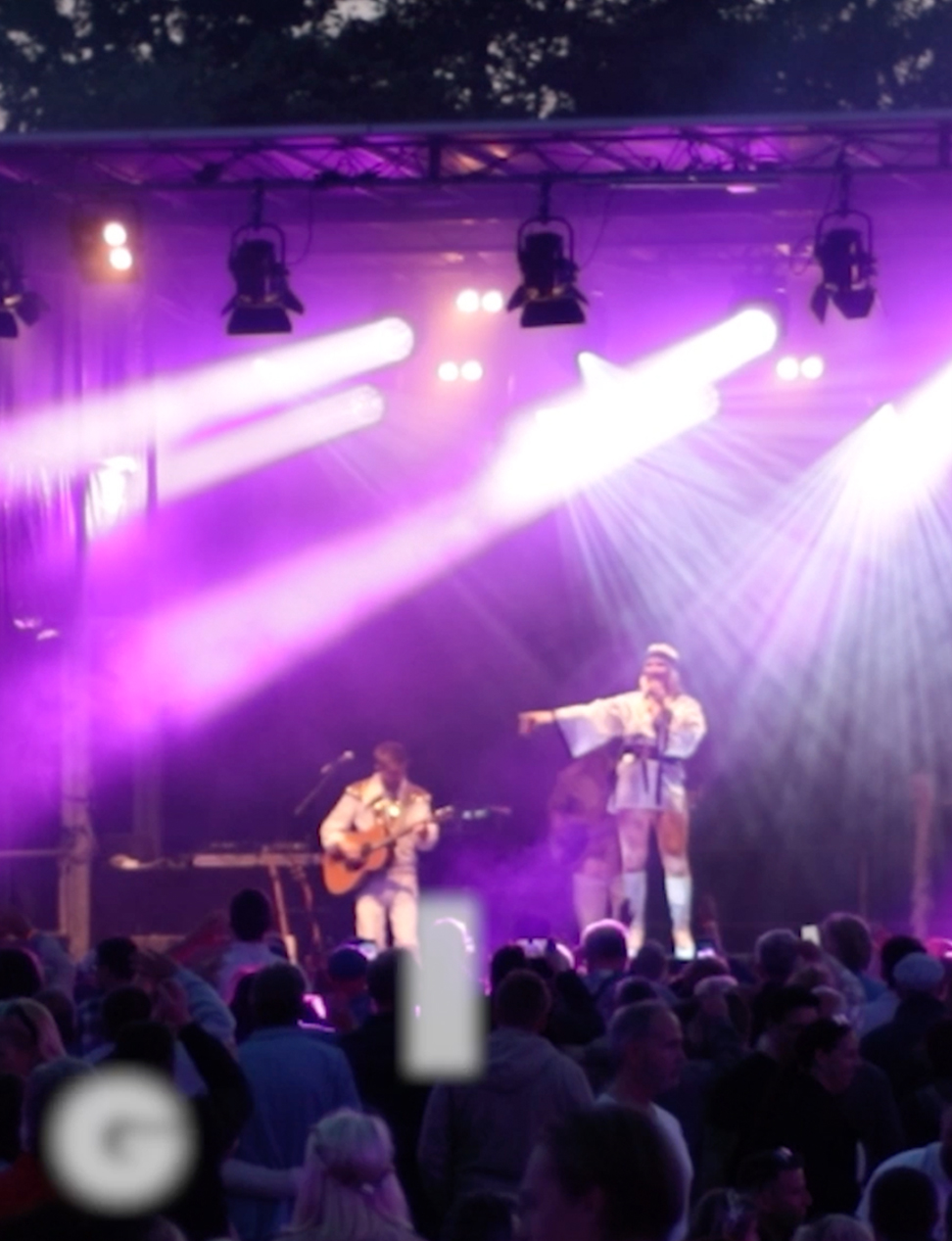 Mann in kurzen Hosen sing auf Bühne, Lightshow