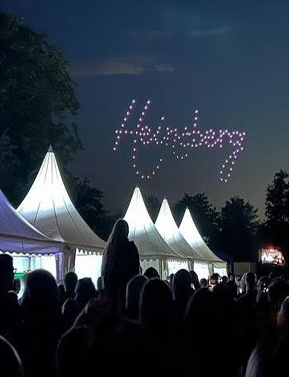 Nächtliches Fest mit Menschen und weißen Zelten